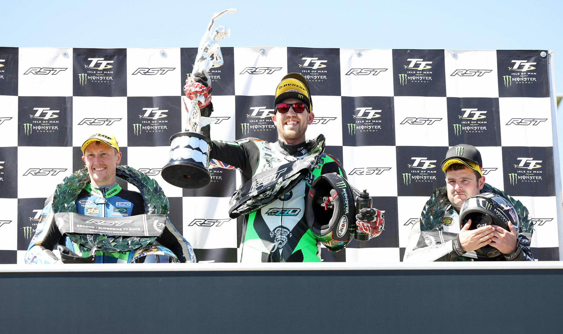 Isle of Man TT 2026: Will Michael Dunlop Ride the Senior Race on Ducati or Honda? 4 Peter Hickman feiert den Superbike-TT-Sieg 2022 mit Dean Harrison und Michael Dunlop auf dem Podium