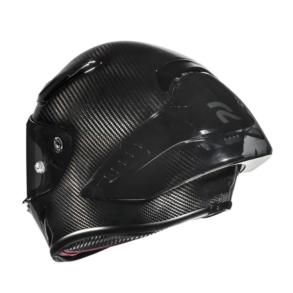 HJC RPHA 1 V2 Carbon: MotoGP Helmet with FIM-02 Standard from 749 Euros 1 HJC RPHA 1 V2 Carbon 2026 – Seitenansicht schräg von vorn, sichtbare Carbon-Gewebestruktur, dunkles Visier, Racing-Spoiler am Heck