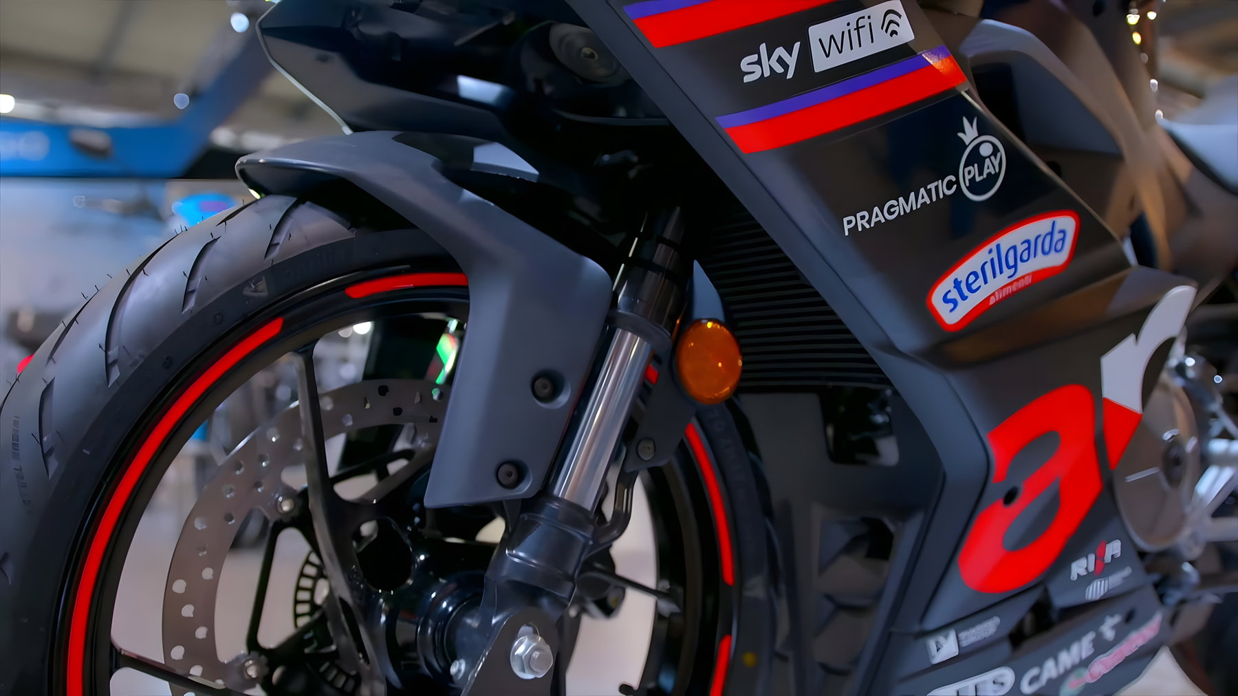 Aprilia RS 457 GP Replica: MotoGP-Flair für die A2-Klasse 3 Aprilia RS 457 GP Replica 2026 – Detailaufnahme Vorderrad mit USD-Gabel, Bremssattel und rot akzentuierter Felge auf Messestand