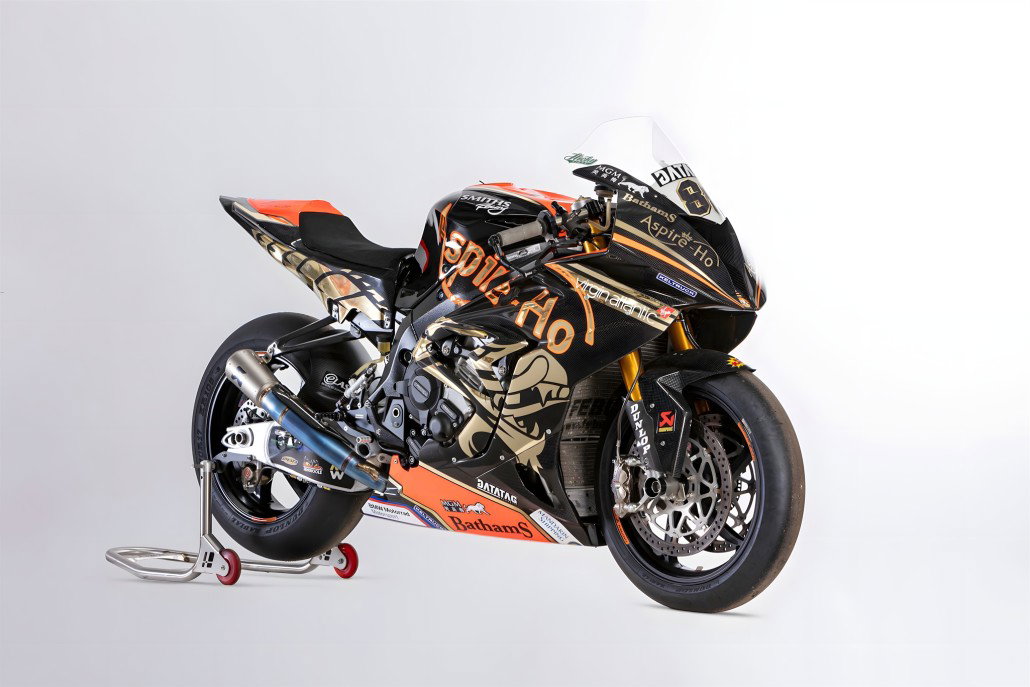 BMW S1000 RR Smiths Racing Peter Hickman 2019 – Frontansicht schräg links im Studio, schwarz-goldene Rennlackierung auf Montageständer mit roten Rollen