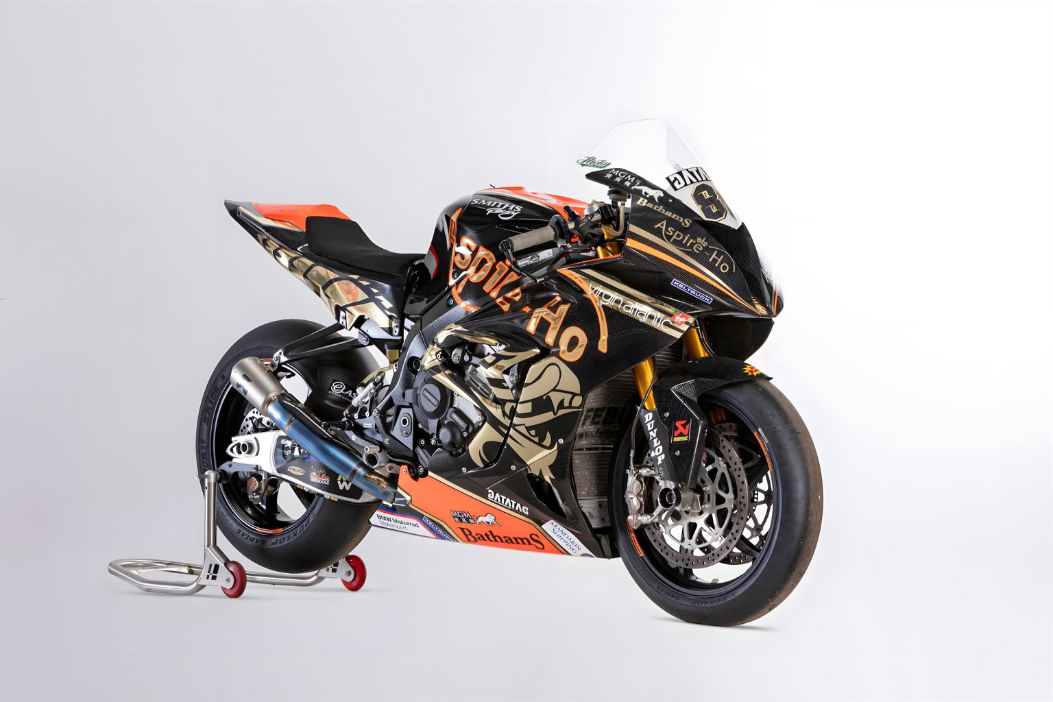 BMW S1000 RR Smiths Racing Peter Hickman 2019 – Frontansicht schräg links im Studio, schwarz-goldene Rennlackierung auf Montageständer mit roten Rollen