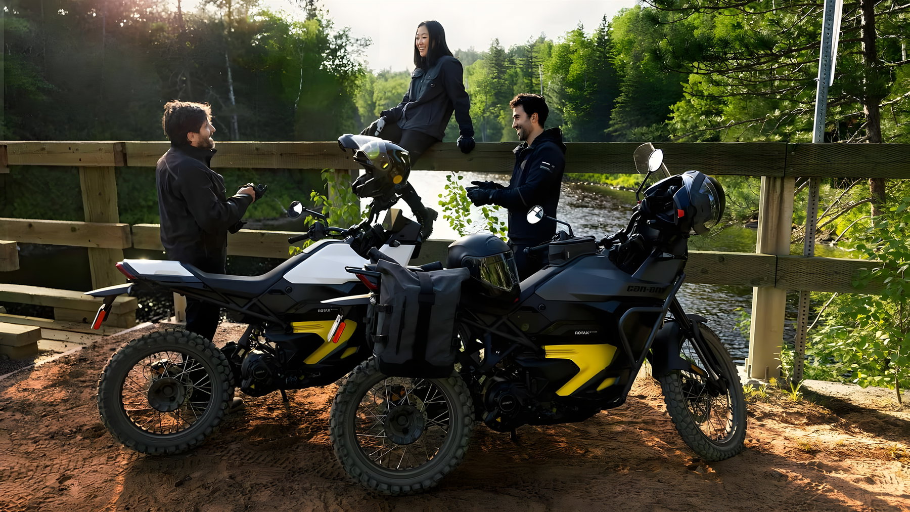 Can-Am Origin 2025 - two white electric motorcycles with three people on a wooden bridge over a river in the forest (hero image for the recall article)