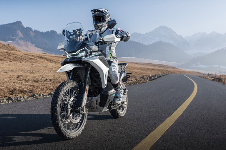 CFMOTO 1000MT-X 2026: Price, Specs, Engine, Features CFMoto 1000MT-X – Frontansicht auf Bergstraße mit Alpen-Panorama, weiße Farbvariante mit Windschild und Sturzbügeln