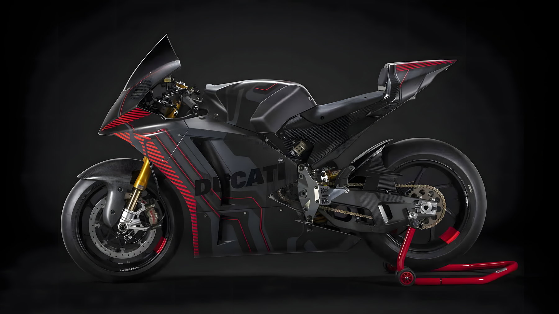 Ducati V21L MotoE prototype 2026 - left side view in black carbon fairing with red accents in the studio