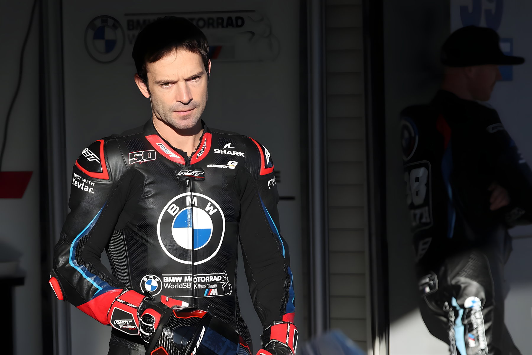 Sega spendet Dark Rider: Guintoli versteigert Sonic-Bike für Stiftung 5 Sylvain Guintoli im Boxenbereich in schwarzer BMW Motorrad WorldSBK Test Team Rennlederkombi von RST mit Shark-Helmlogo und BMW-Emblem