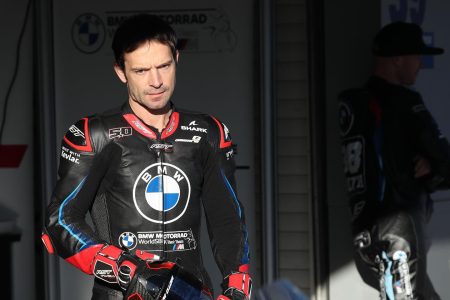 Sylvain Guintoli im Boxenbereich in schwarzer BMW Motorrad WorldSBK Test Team Rennlederkombi von RST mit Shark-Helmlogo und BMW-Emblem