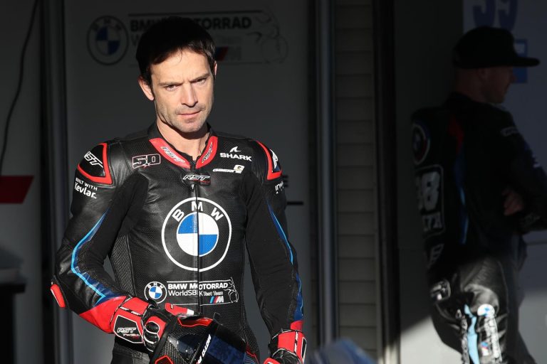 Sylvain Guintoli im Boxenbereich in schwarzer BMW Motorrad WorldSBK Test Team Rennlederkombi von RST mit Shark-Helmlogo und BMW-Emblem