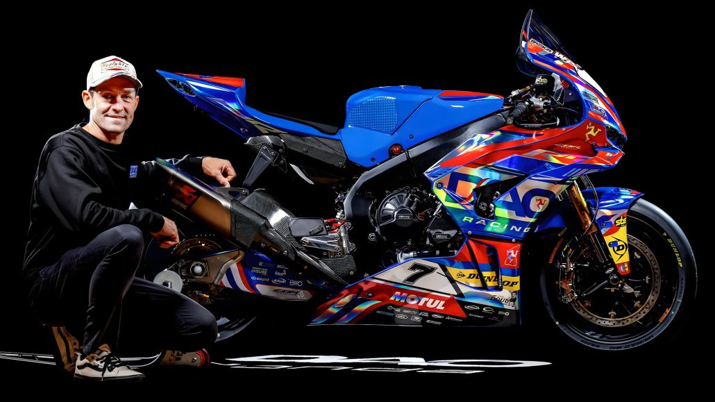 Josh Brookes kniet neben seiner DAO Racing Ducati Panigale im Studiofoto – Superbike in blau-rot-orangener Rennlackierung mit Motul- und Dunlop-Sponsoring