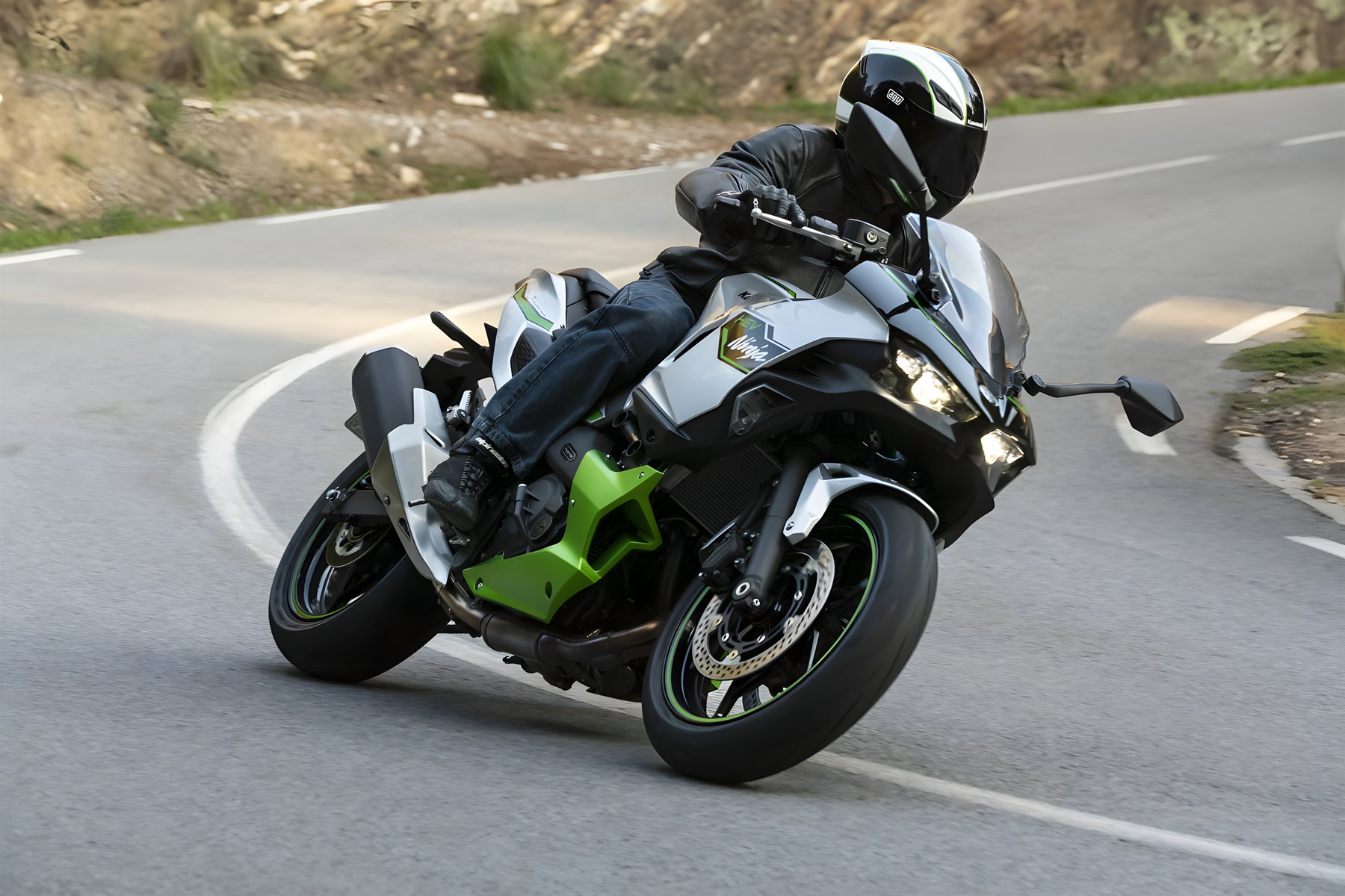 Kawasaki Ninja 7 Hybrid und Z7 Hybrid: Software-Update macht die Hybrid-Motorräder alltagstauglicher 3 Kawasaki Ninja 7 Hybrid 2026 – Fahraufnahme in Schräglage auf Landstraße mit Fahrer in schwarzer Motorradkleidung