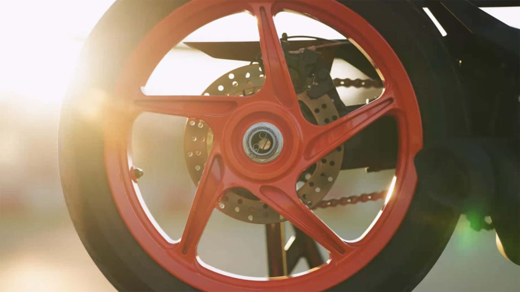 KTM RC 450 2026 – Detailansicht orangefarbene Hinterradfelge mit Bremsscheibe im Gegenlicht