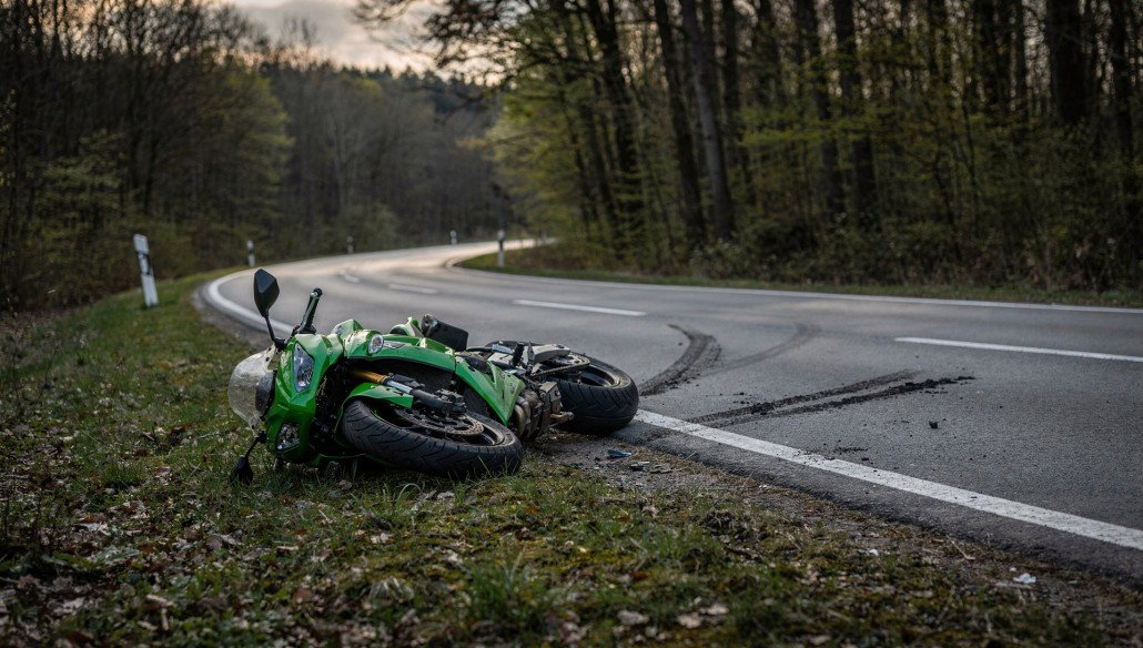Grüne Kawasaki-Sportmaschine liegt nach Sturz am Rand einer kurvigen Waldstraße, Symbolbild zum Motorradunfall auf der L 3196 bei Steinau an der Straße