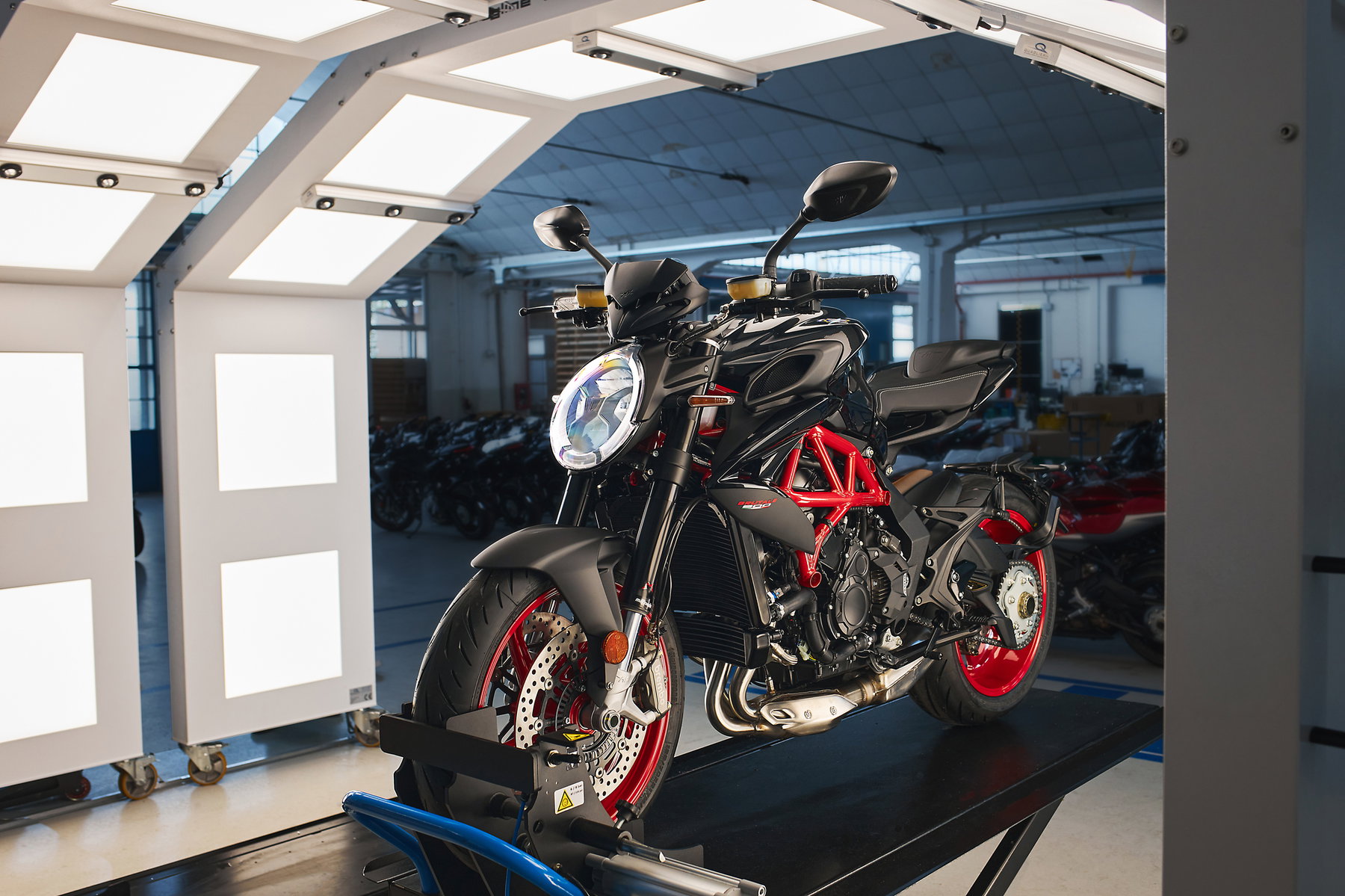 MV Agusta Brutale 800 Nero Carbonio 2026 – Frontansicht schräg rechts mit tropfenförmigem LED-Scheinwerfer, Marzocchi-USD-Gabel, Brembo-M4.32-Radialbremsen und rotem Gitterrohrrahmen in der Werkshalle