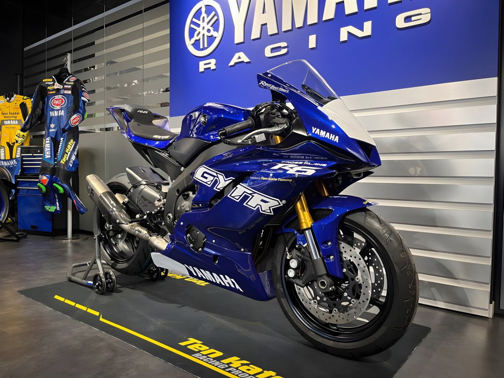 Yamaha R6 Crossplane Ten Kate – Dreiviertelansicht vorne rechts im Showroom mit goldenen Öhlins-Gabeln