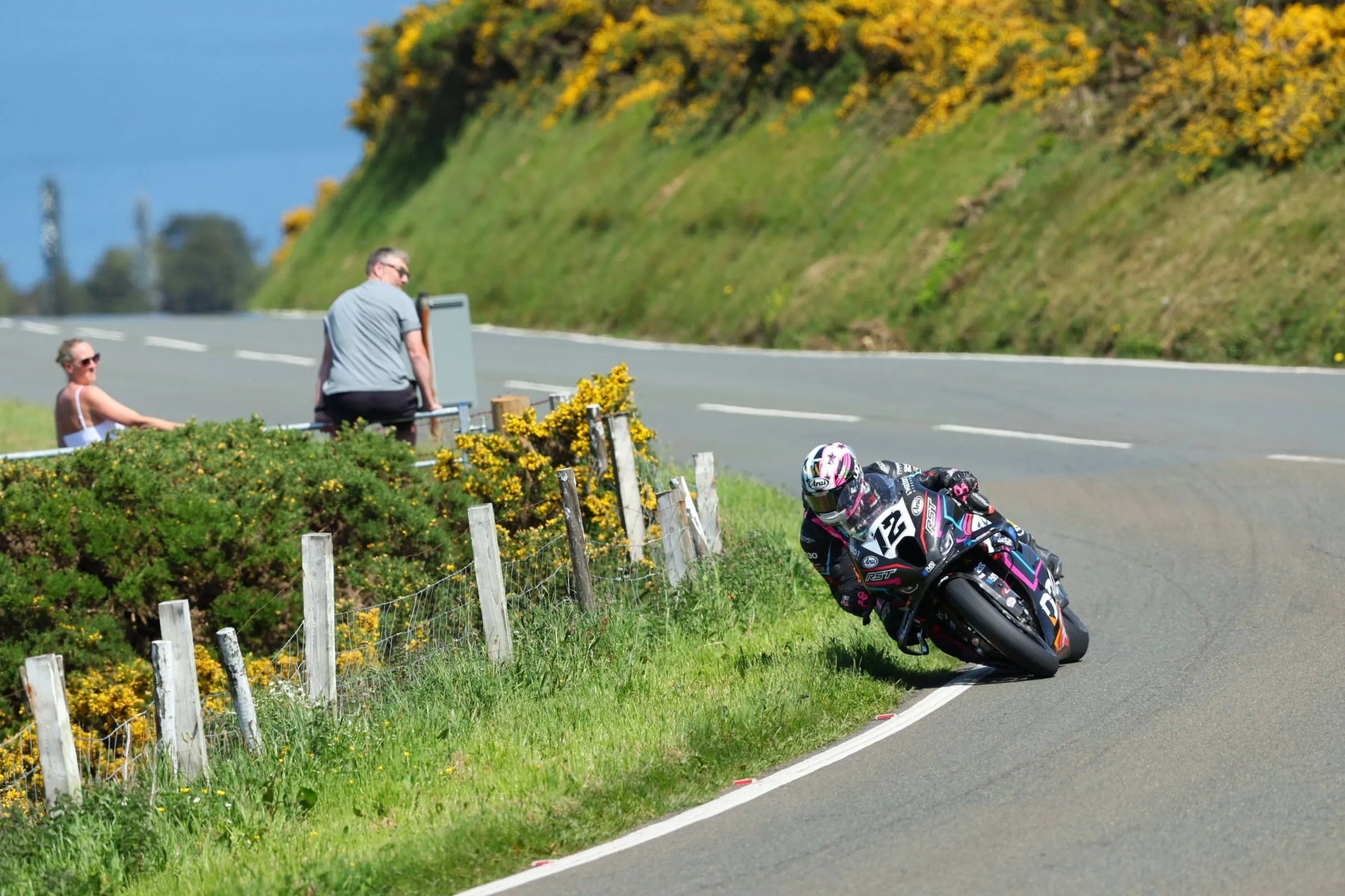 Isle of Man TT 2026: Parliament Square für Zuschauer dauerhaft gesperrt, zwei Verletzte weiterhin im Krankenhaus 3 Startnummer 12 auf dunklem Superbike in Schraglage mit Zuschauern am Streckenrand – Isle of Man TT 2026 Free Practice