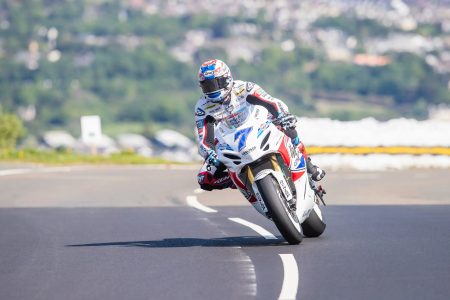 Startnummer 7 auf weiss-rot-blauem Superbike in Schraglage mit Douglas im Hintergrund – Isle of Man TT 2026 Free Practice