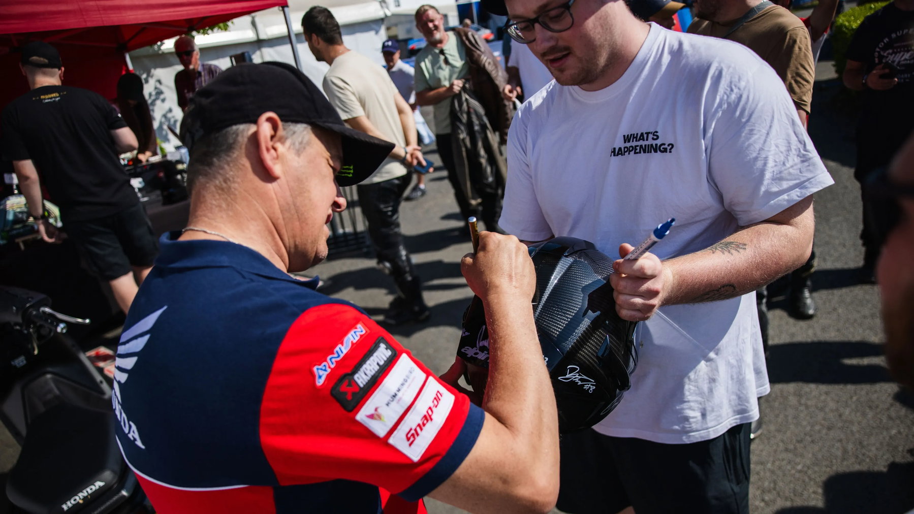 John McGuinness will weitermachen: 2027 hängt jetzt an Honda 7 John McGuinness signiert einen Helm für einen Fan im Paddock – Isle of Man TT 2026
