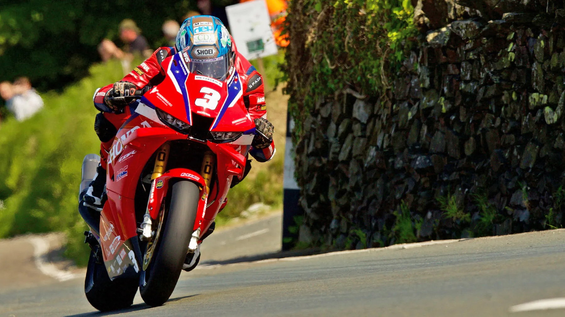 Isle of Man TT: Harrison Dominates, Superstock Podium Wide Open 1 Dean Harrison mit Startnummer 3 auf der Honda Superstock in Schräglage an Steinmauer – Isle of Man TT 2026 Qualifying