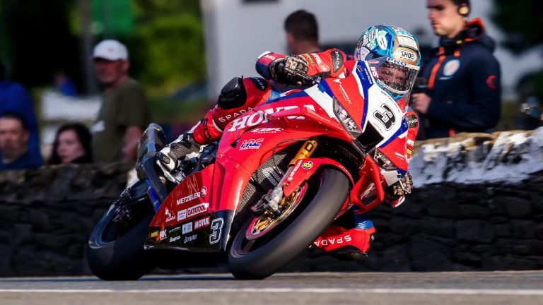 Dean Harrison auf der roten Honda Racing UK Nummer 3 in Schräglage vor Zuschauern an Steinmauer – Isle of Man TT 2026 Qualifying Rekordrunde