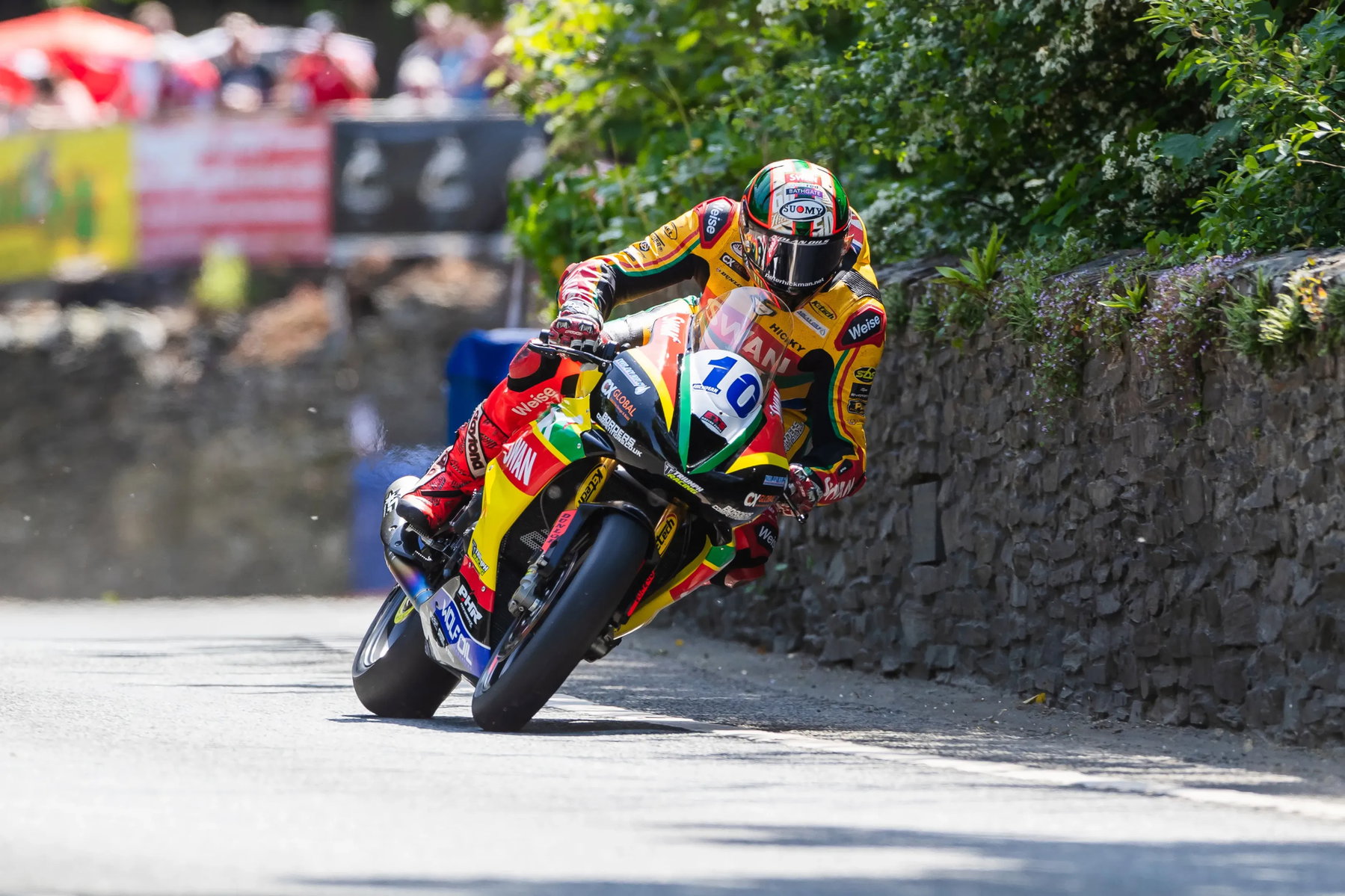 Peter Hickman mit Startnummer 10 auf der Triumph in Schräglage vor Zuschauern – Isle of Man TT 2026 Qualifying Supersport