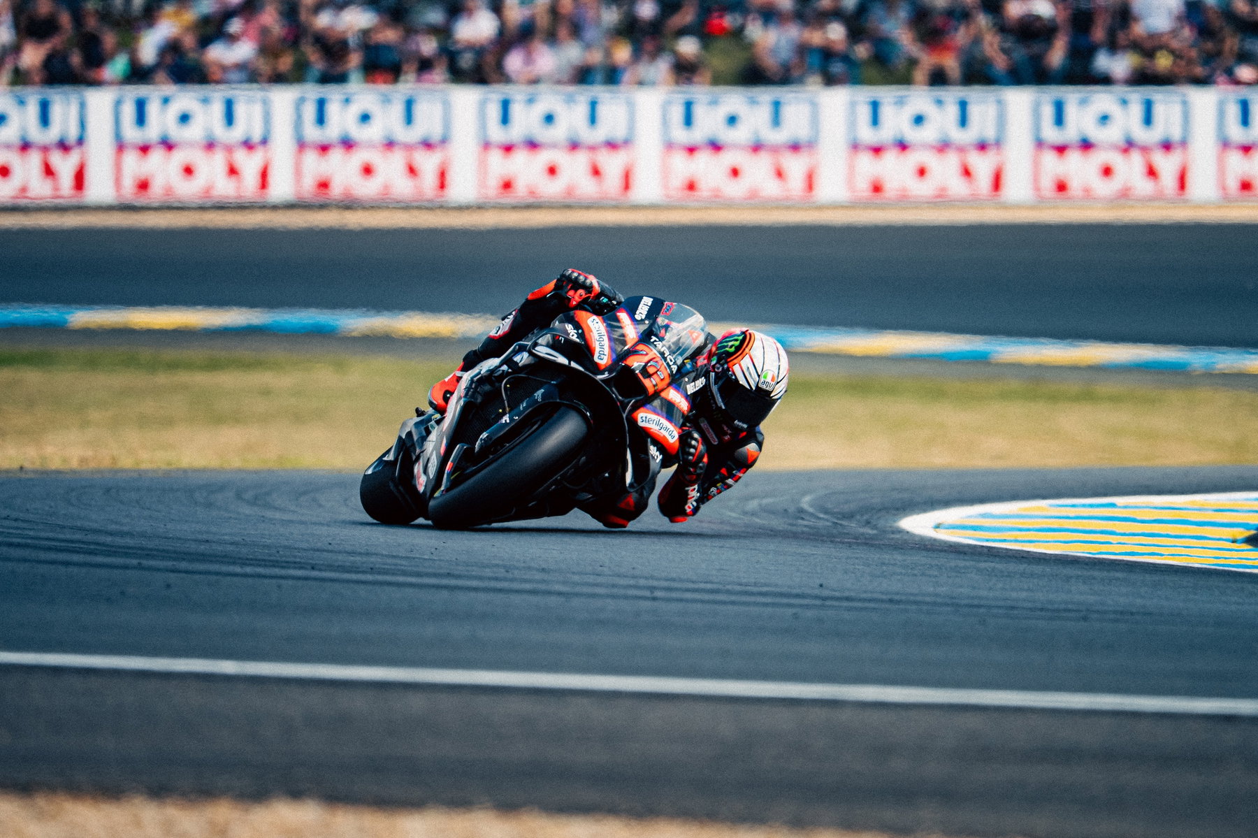 Marco Bezzecchi Aprilia RS-GP in Schräglage mit Liqui-Moly-Banner und Zuschauern – MotoGP Frankreich GP Le Mans 2026