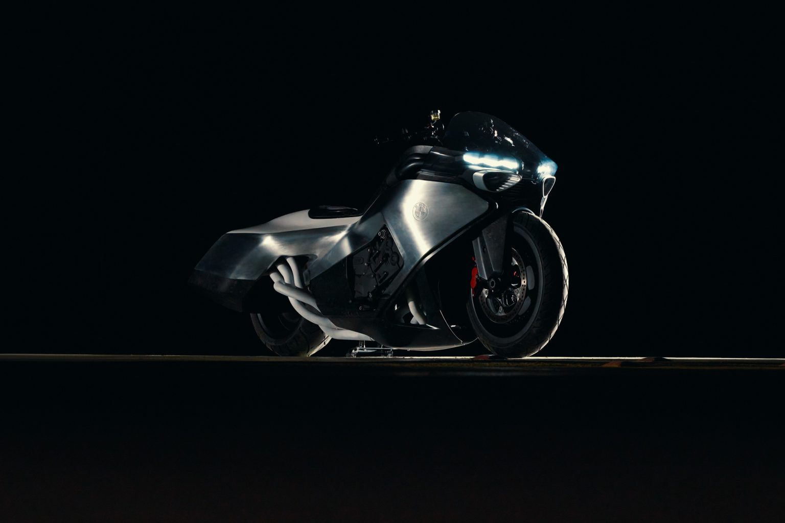 BMW Motorrad Vision K18 – rechte Seitenansicht bei Nacht mit sichtbarem Reihen-Sechszylinder und Auspuffkrümmer