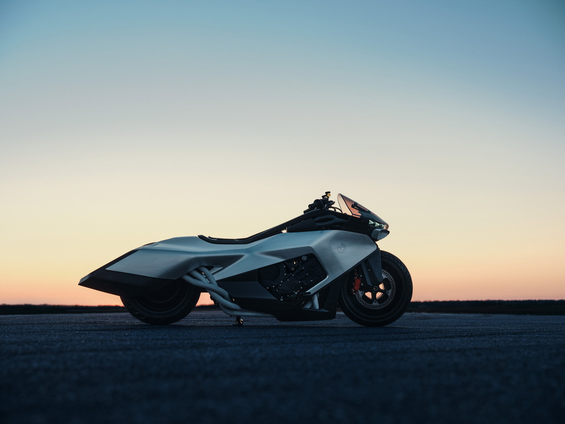 BMW Motorrad Vision K18 – right side view on a runway at sunset with aluminum bodywork and visible engine