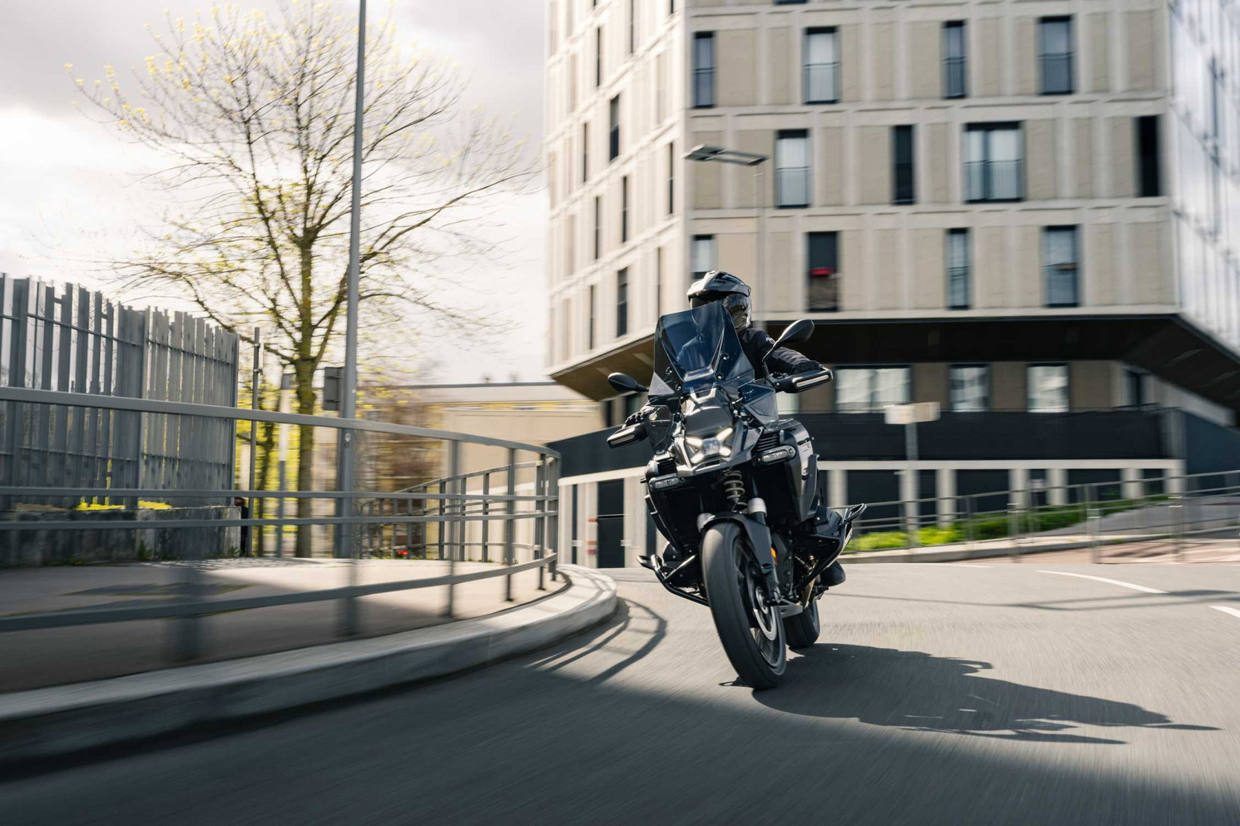 BMW R 1300 GS Adventure Dark Edition 2026 – Fahraufnahme in Kurve, schwarze Lackierung und dunkle Felgen
