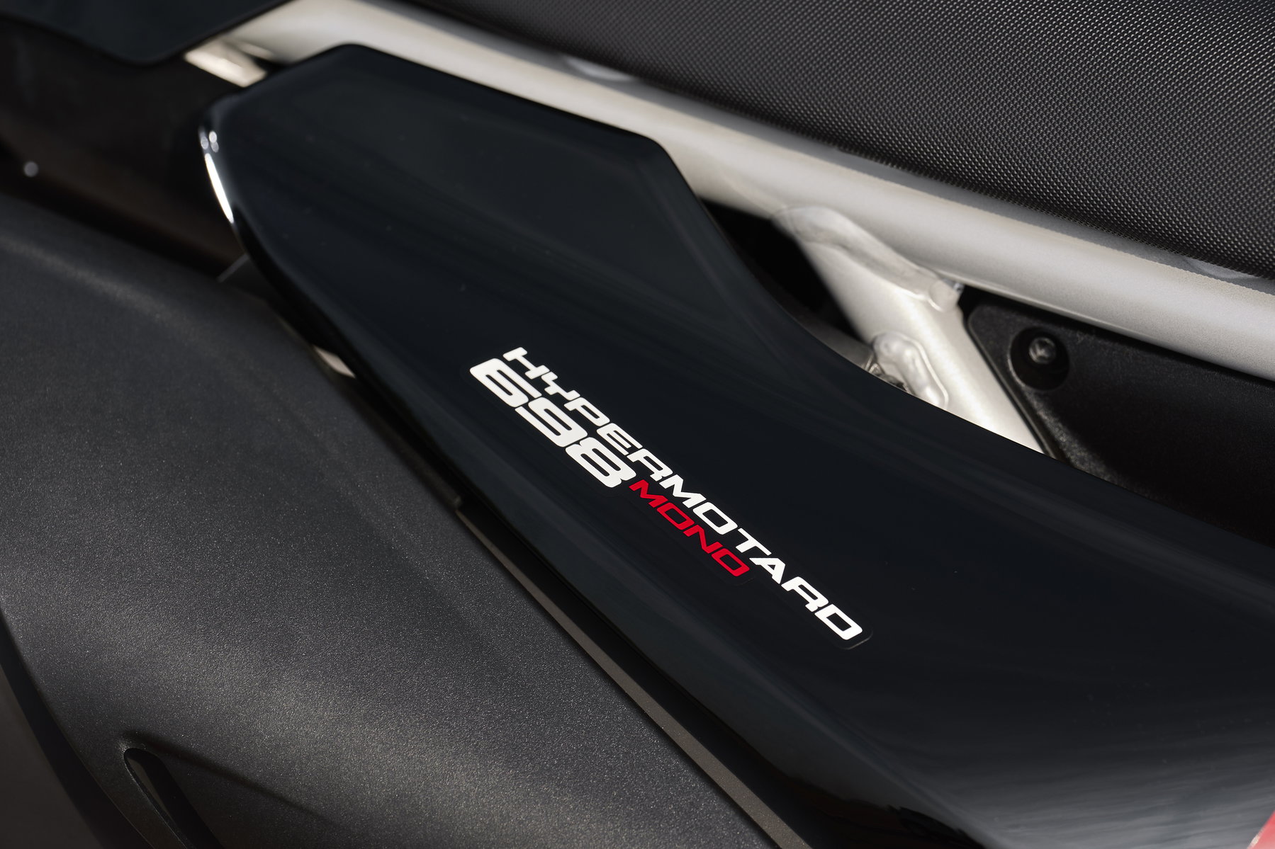 Ducati Hypermotard 698 Mono Nera 2027 – Nahaufnahme des Hypermotard 698 Mono Schriftzugs auf der schwarzen Seitenverkleidung mit rotem Mono-Akzent