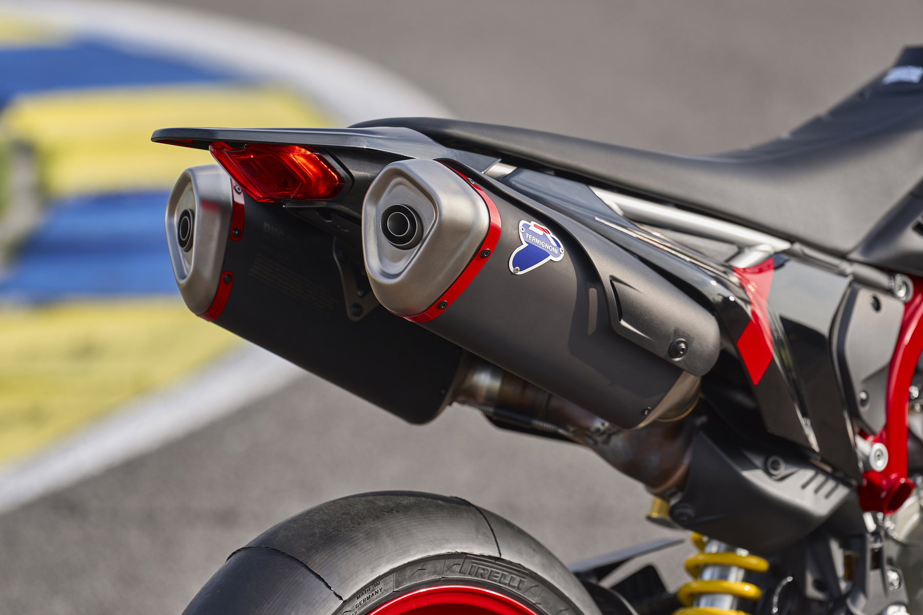 Ducati Hypermotard 698 Mono Nera 2027 – Heckansicht mit serienmäßigen Termignoni-Schalldämpfern aus Stahl mit schwarzer Oberfläche und roten Details auf Rennstrecke