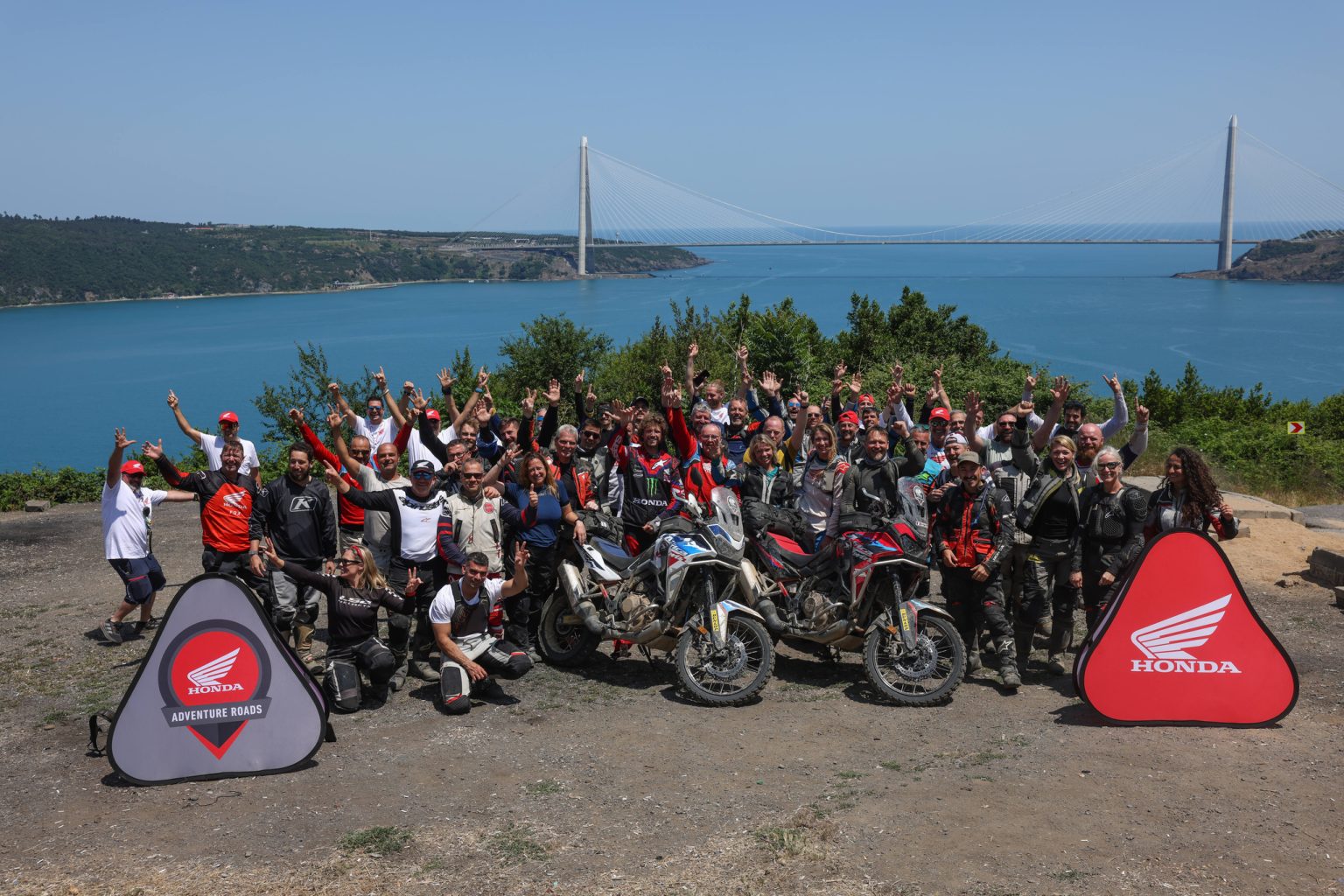 Honda Adventure Roads – Gruppenaufnahme der Teilnehmer mit Honda Africa Twin Motorrädern vor Bosporusbrücke in Istanbul