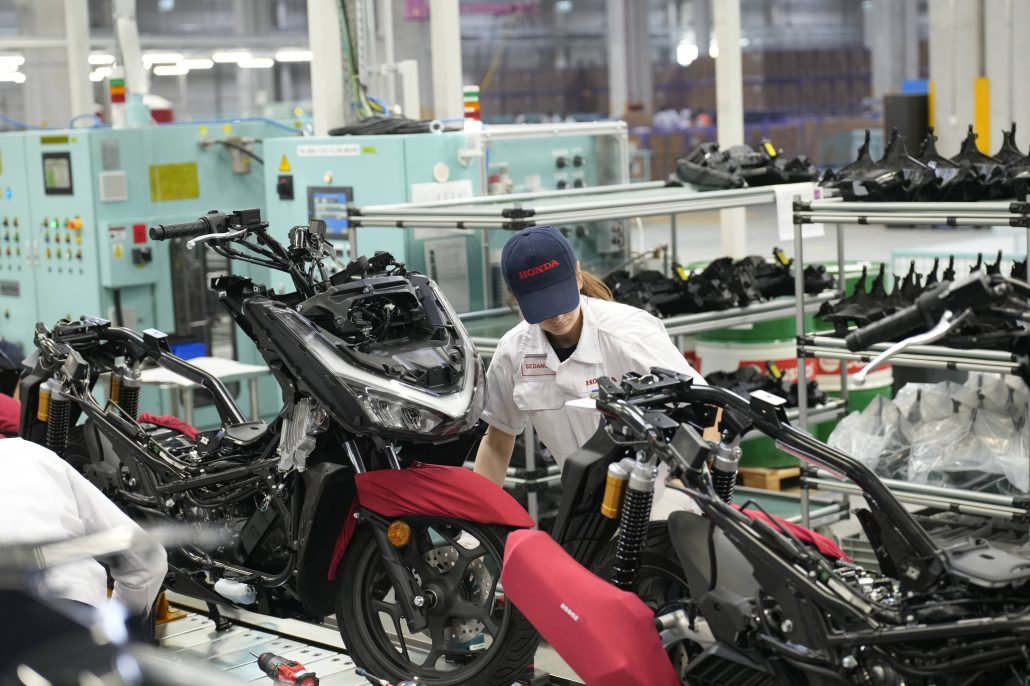 Honda Motorradwerk Türkei 2026 – Arbeiterin in Honda-Uniform bei der Rollermontage am Fließband im Werk Aliağa