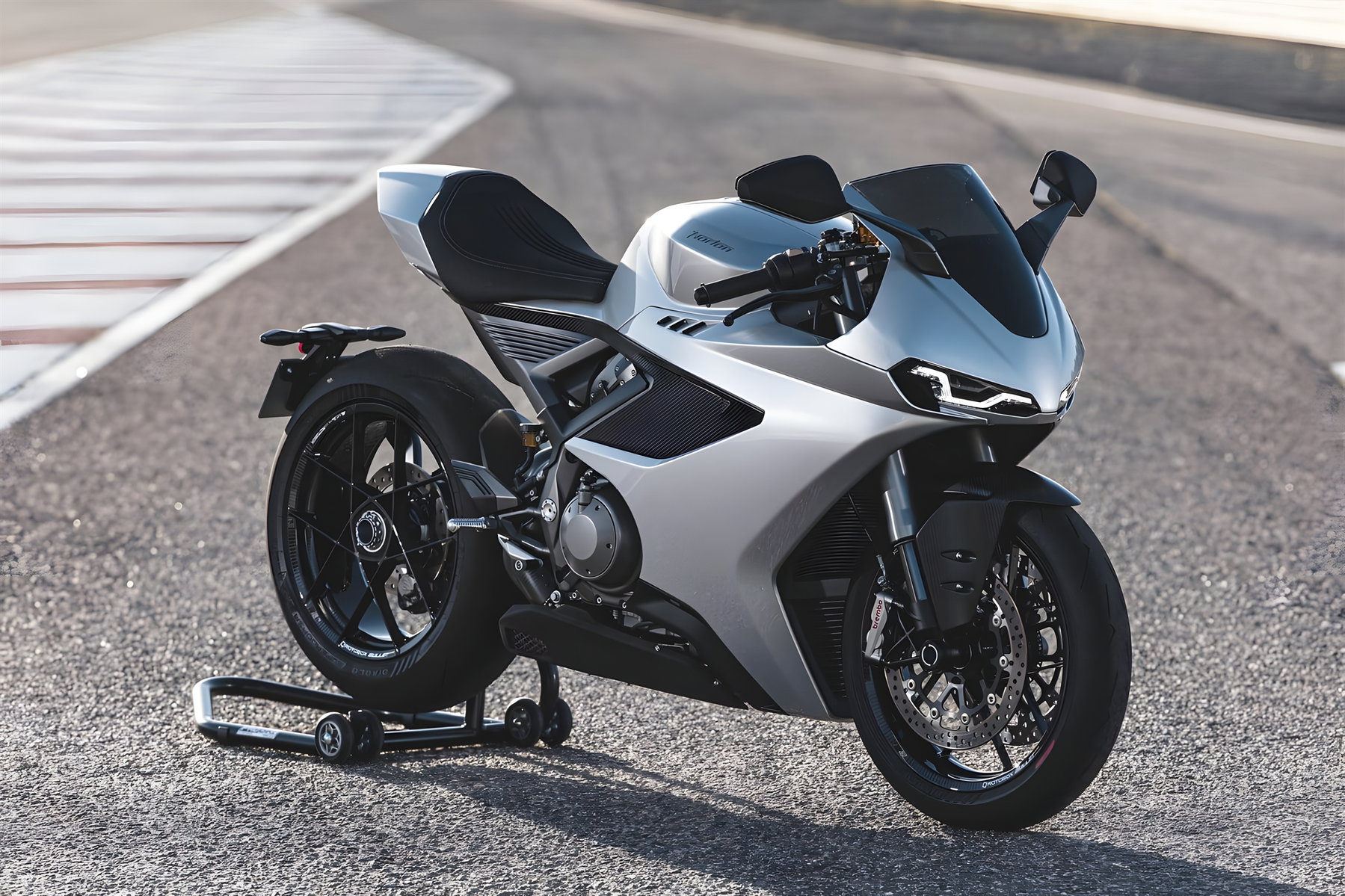 Norton Manx R gewinnt IDEA Award: Was hinter dem Designpreis steckt 6 Norton Manx R Signature 2026 – Dreiviertelansicht von vorn rechts in Silber auf dem Circuito Monteblanco auf Montageständer