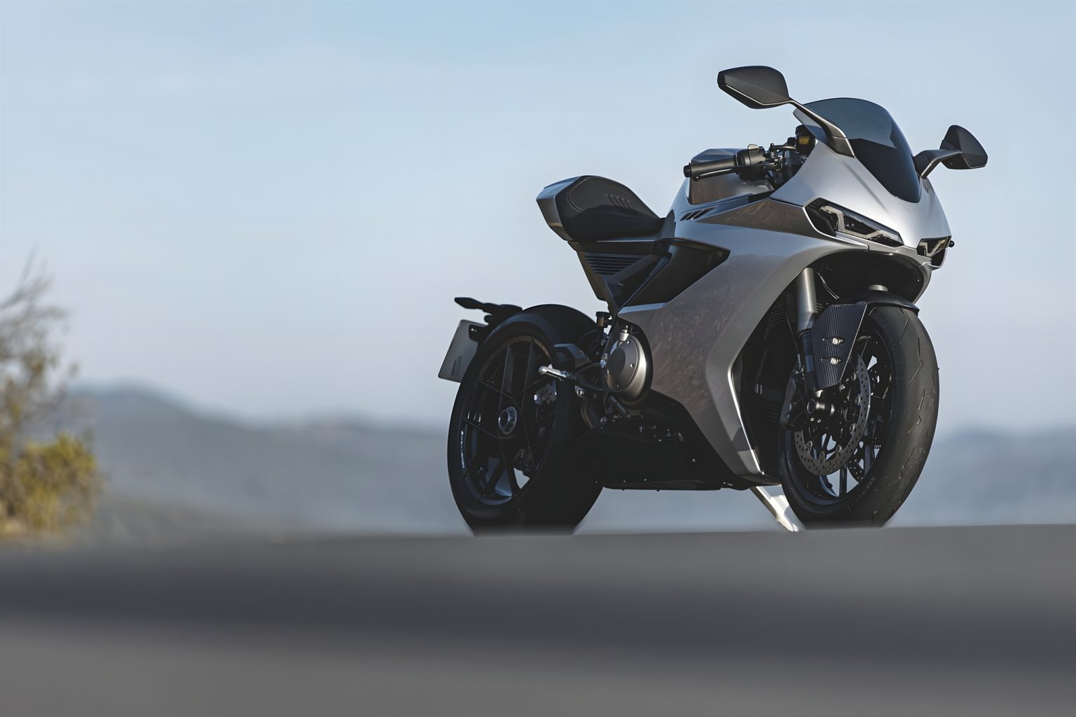 Norton Manx R With Suspension Travel Sensors: What Changes For Riders Norton Manx R Signature 2026 – Dreiviertelansicht von vorn rechts in Silber vor Wüstenlandschaft in der Abenddämmerung