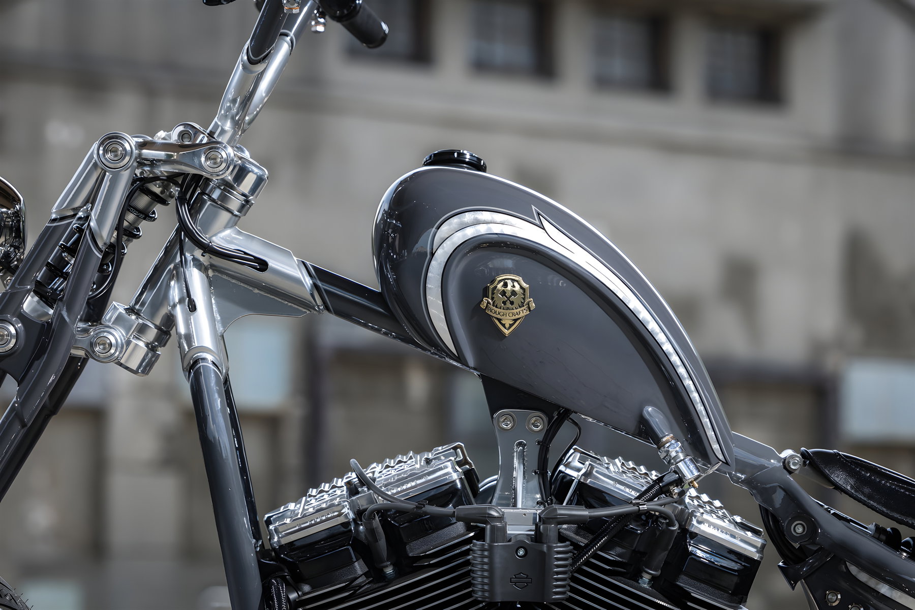 Aeternum Blade: Rough Crafts verwandelt die Harley-Davidson Street Bob in einen modernen Chopper 5 Rough Crafts Aeternum Blade Harley-Davidson Street Bob – Nahaufnahme von links oben auf Frisco-Tank mit Nardo Grey Lackierung, Blattsilber-Pinstriping, goldenem Rough Crafts Emblem und Rough Crafts x Arlen Ness Ventildeckel