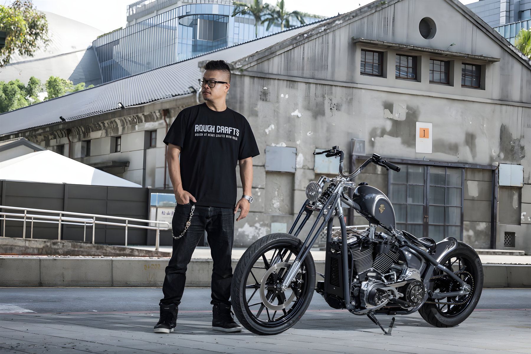 Aeternum Blade: Rough Crafts verwandelt die Harley-Davidson Street Bob in einen modernen Chopper 2 Rough Crafts Aeternum Blade Harley-Davidson Street Bob – Erbauer Winston Yeh im Rough Crafts T-Shirt posiert neben seinem Custom Chopper vor Industriegebäude in Taipeh