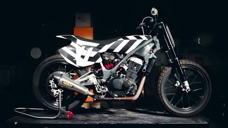 Royal Enfield Sherpa FT Mk2 – Seitenansicht im dunklen Werkstatt-Studio mit Arrow-Auspuff und roten Federbein-Details