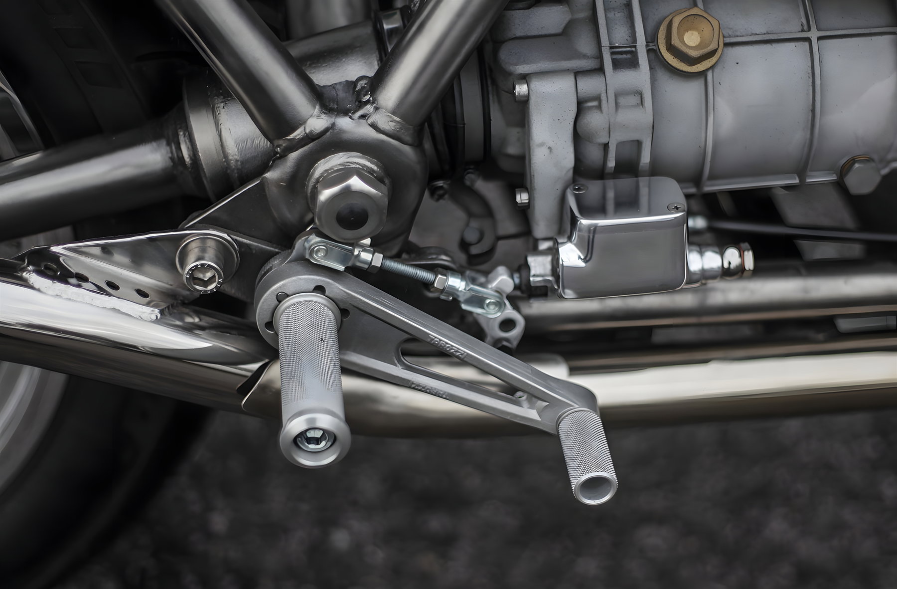 Shiny Hammer Moto Guzzi 1000 SP Café Racer – Detailaufnahme der gefrästen Aluminium-Fußrastenanlage mit gerändelten Rasten und Schaltgestänge