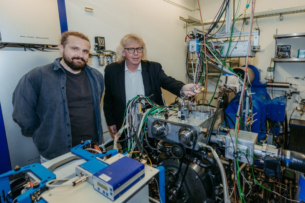 Wasserstoff-Kreislaufmotor Magdeburg 2026 – Offizielles Pressefoto von Aristidis Dafis und Prof. Rottengruber am Einzylinder-Versuchsmotor auf dem Campus der Uni Magdeburg (Foto: Jana Dünnhaupt)