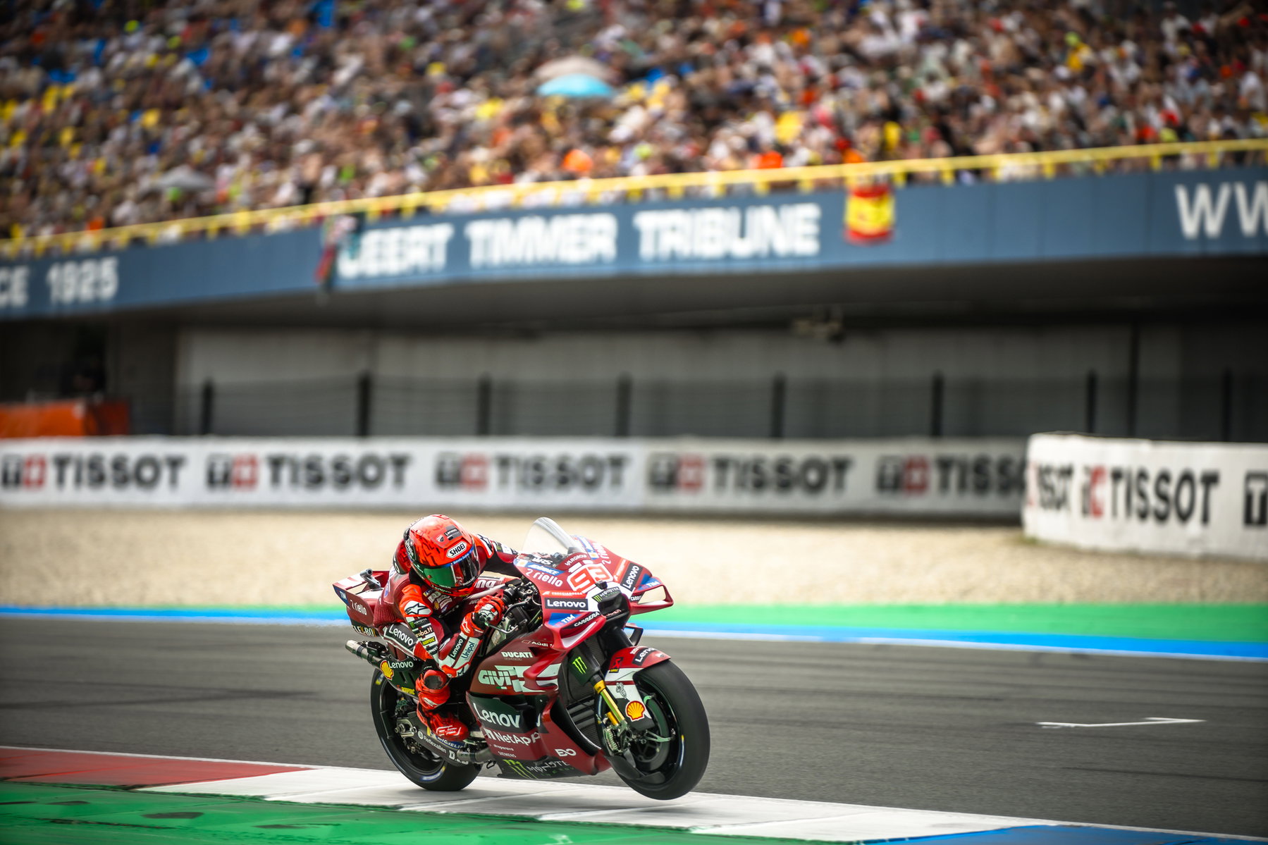 Marc Márquez in Schräglage auf der roten Ducati Desmosedici GP vor der Geert-Timmer-Tribüne in Assen – MotoGP Dutch GP Assen 2026