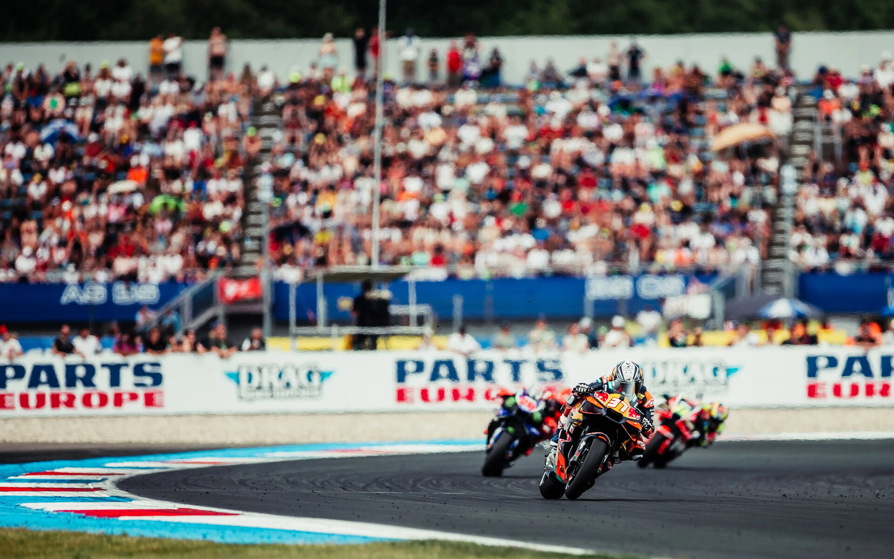 Pedro Acosta führt auf der Red Bull KTM RC16 eine Gruppe vor der großen Tribüne in Assen an – MotoGP Dutch GP Assen 2026
