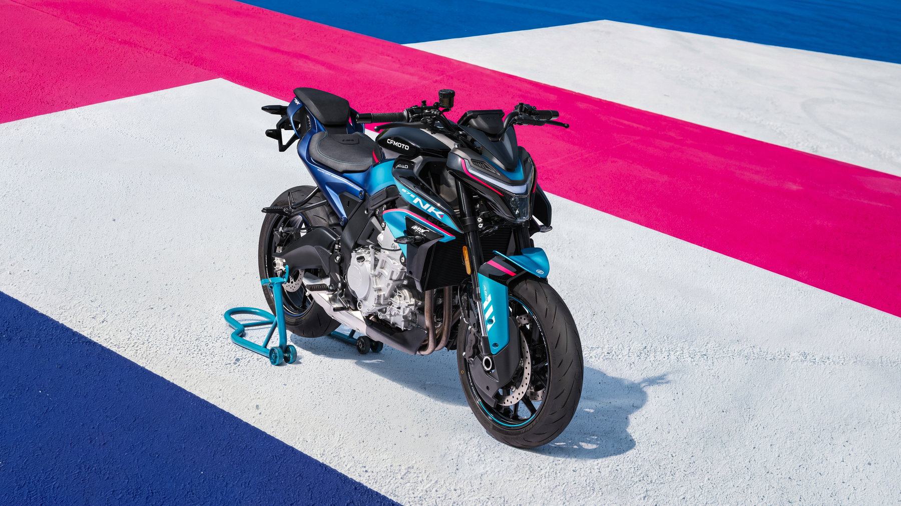 CFMoto 675 NK Aspar Edition: Rennoptik ohne Aufpreis, nur 300 Stück 4 CFMOTO 675NK 2026 in Champion Blue – Front-Schrägansicht von rechts auf farbig markierter Rennstrecke mit Montageständer