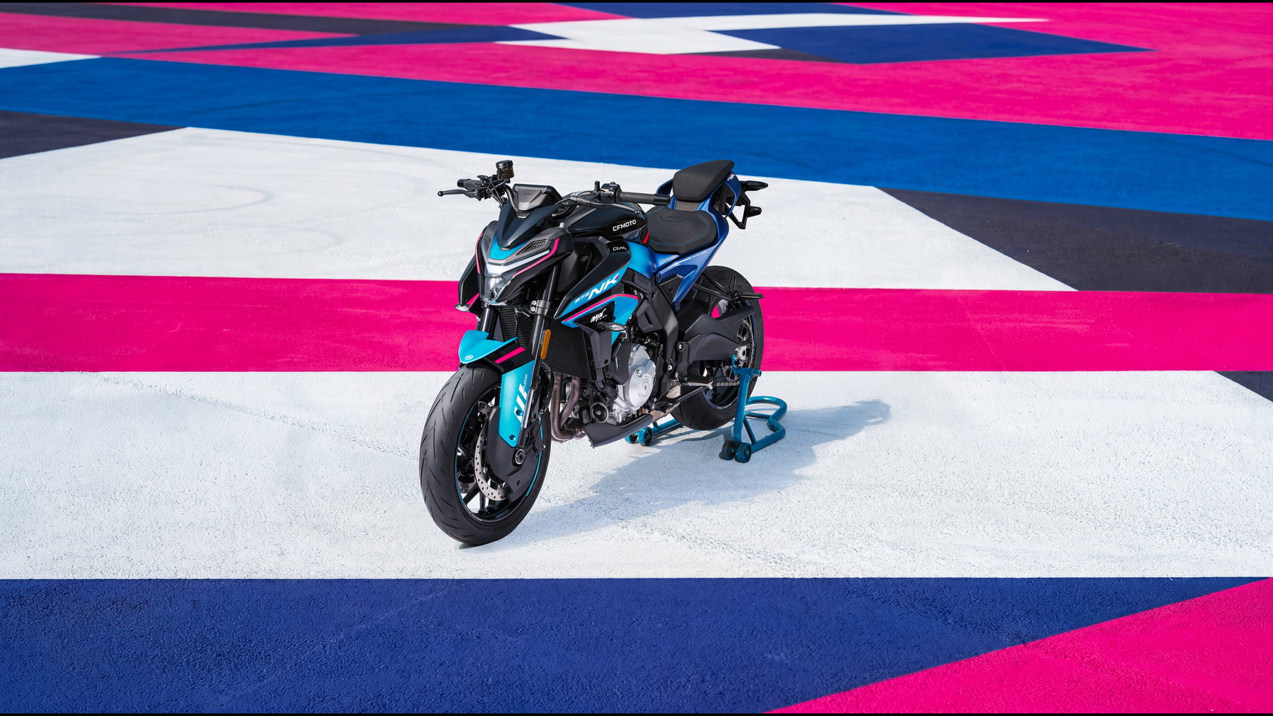 CFMOTO 675NK 2026 in Champion Blue – frontale Aufsicht auf das Naked Bike auf einer bunt gestalteten Rennstrecken-Fläche