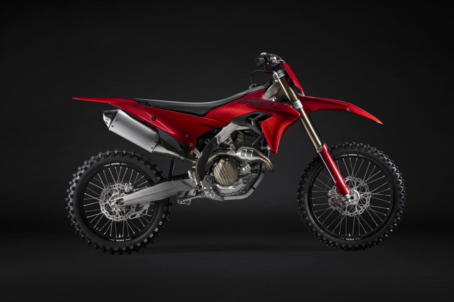 Ducati Desmo250 MX kommt: Desmodromik erobert die 250er-Klasse Ducati Desmo250 MX 2027 in Ducati Red – Seitenansicht von links im Studio mit Desmodromik-Einzylinder, Aluminium-Schwinge und Edelstahl-Auspuff