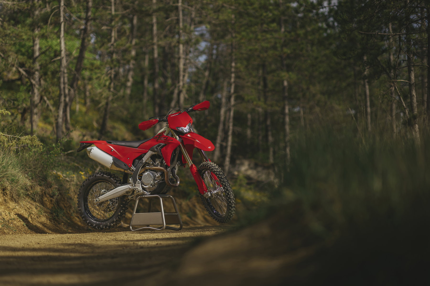 Ducati Desmo450 EDS: Erste straßenzugelassene Enduro mit Desmodromik 3 Ducati Desmo450 EDS 2027 auf Montageständer im Wald