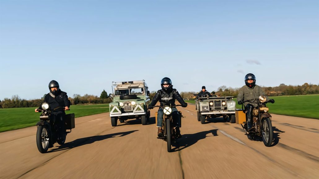 Jason Momoas 1920er-Harley wird zum Plug-in-Hybrid: Technik im Detail 7 Alle vier Electrogenic-Conversions in Formation fahrend auf Landstraße – drei Motorradfahrer auf zwei Harley-Davidson Modellen und zwei Land Rover dahinter, Frontperspektive