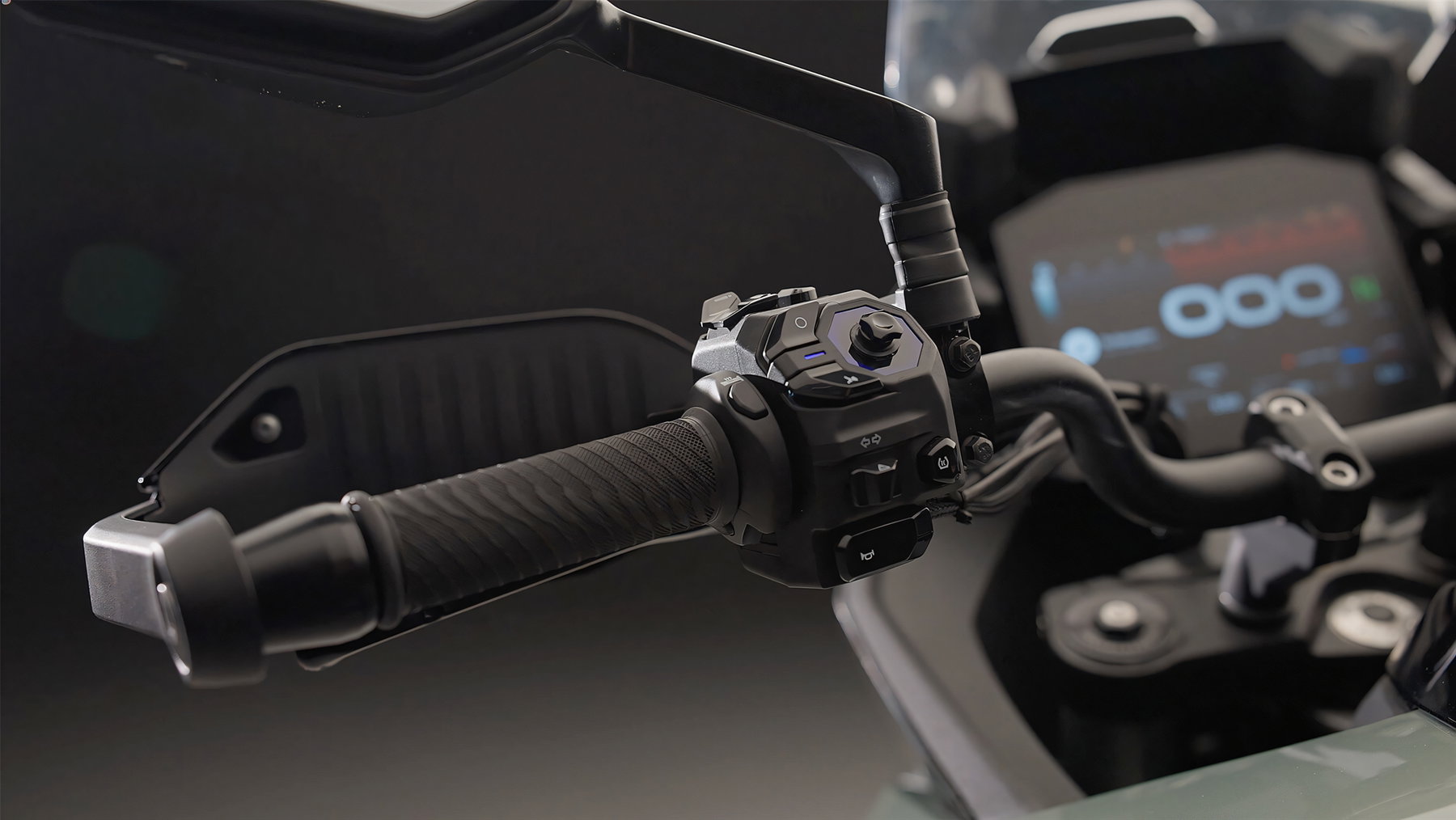 Norton Atlas und Atlas GT: Briten greifen in der Adventure-Mittelklasse an 4 Norton Atlas GT 2026 – Detail des linken Lenkergriffs mit Schaltereinheit, Bar-End-Gewicht und TFT-Display im Hintergrund