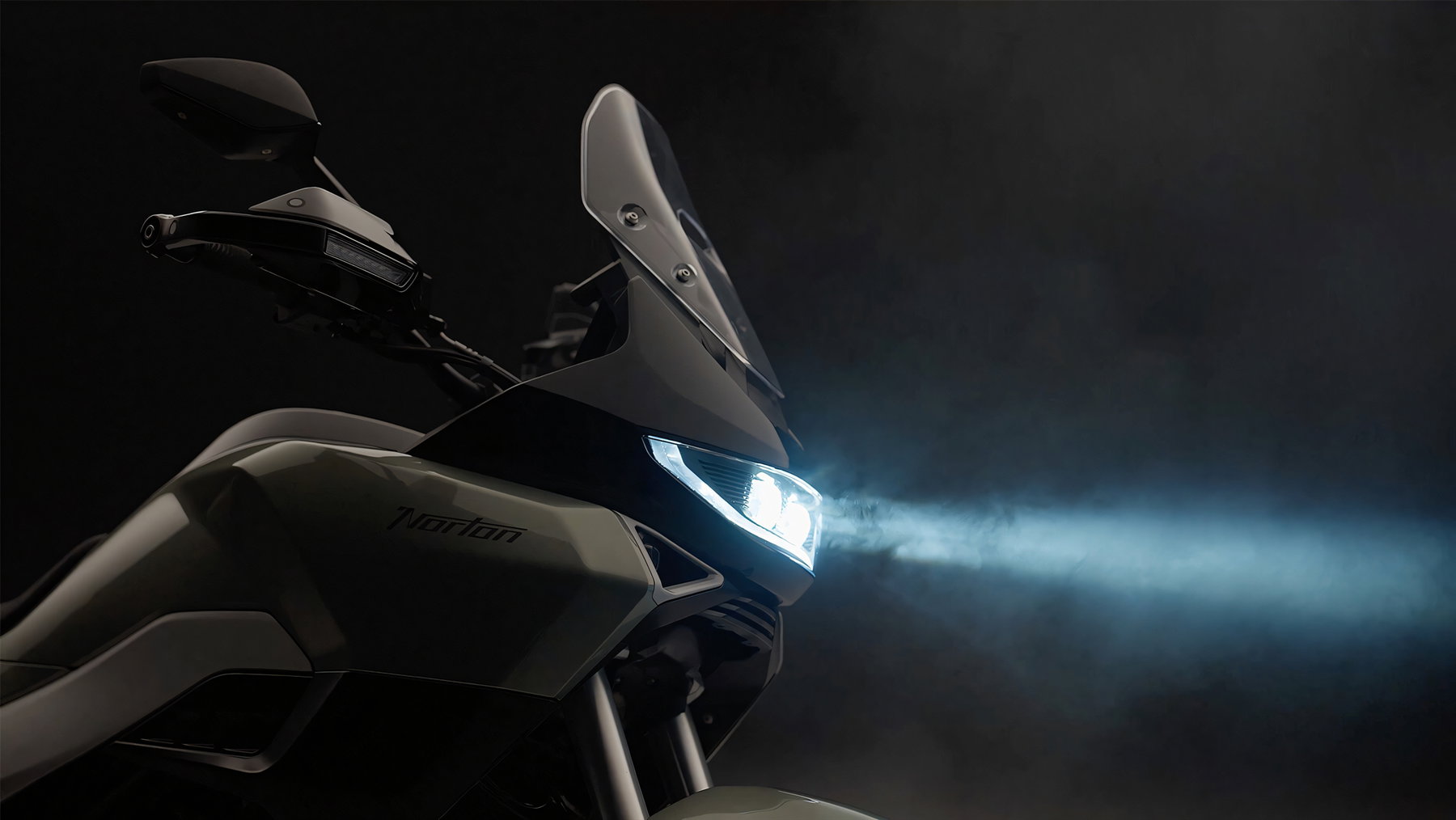 Norton Manx R With Suspension Travel Sensors: What Changes For Riders 2 Norton Atlas GT 2026 – front end with windscreen and illuminated LED headlight in a dark studio setting