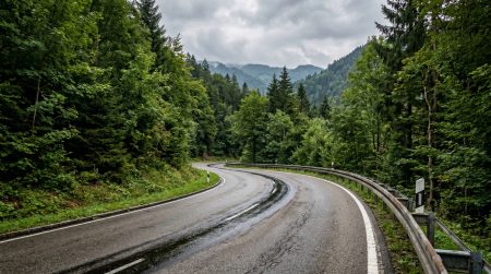 Ölfallen im Allgäu: Neuer Fall auf der B308 weckt Erinnerung an 2011 Nasse S-Kurve auf einer bewaldeten Bergstraße im Allgäu mit Leitplanken und dichtem Mischwald – symbolisiert die Gefahr von Ölspuren auf kurvenreichen Landstraßen für Motorradfahrer