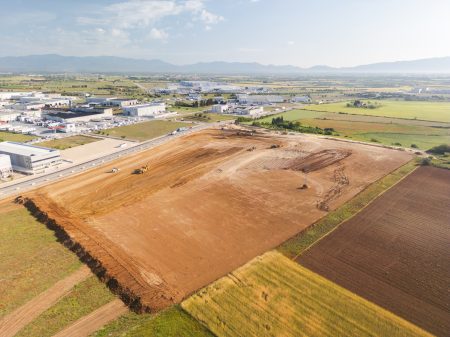 Rieju Werk Vilamalla – Luftaufnahme der Baustelle im Industriegebiet Empordà Internacional mit Erdarbeiten, Baumaschinen und umliegenden Feldern bei Girona