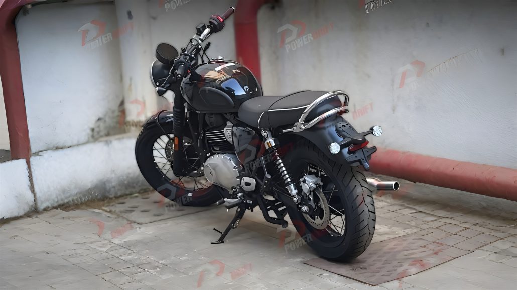 Triumph Bonneville 400 2026 – Erlkönig-Gesamtansicht schräg rechts hinten in Schwarz mit Doppelfederbein, Einzylinder-Motor, Speichenfelgen und Hauptständer vor Betonwand